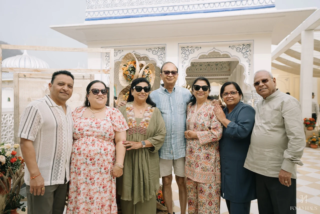 A group of guests smiling together in the palace courtyard.