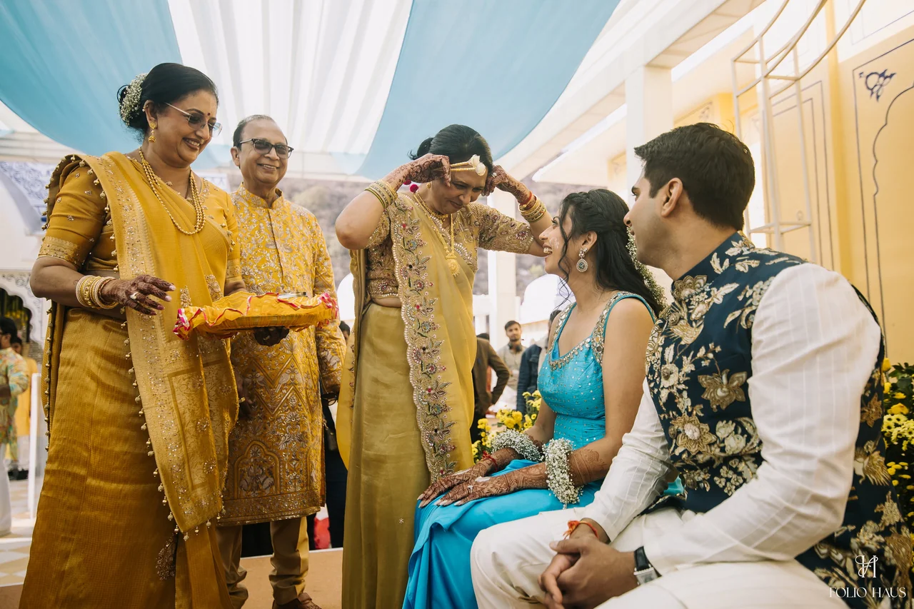 Guests smiling around Jigna and Anurag during Haldi.