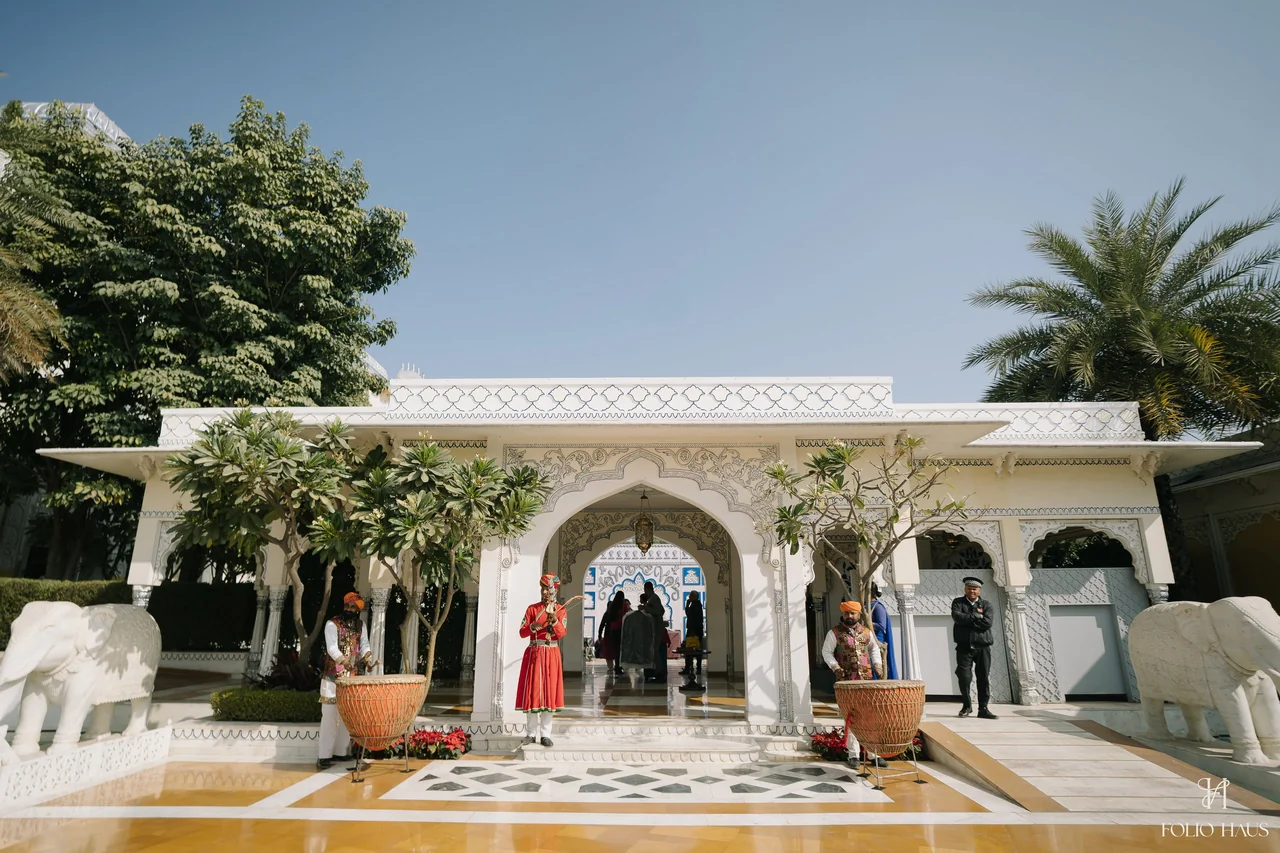 White palace courtyard prepared with flowers for the Haldi celebration.