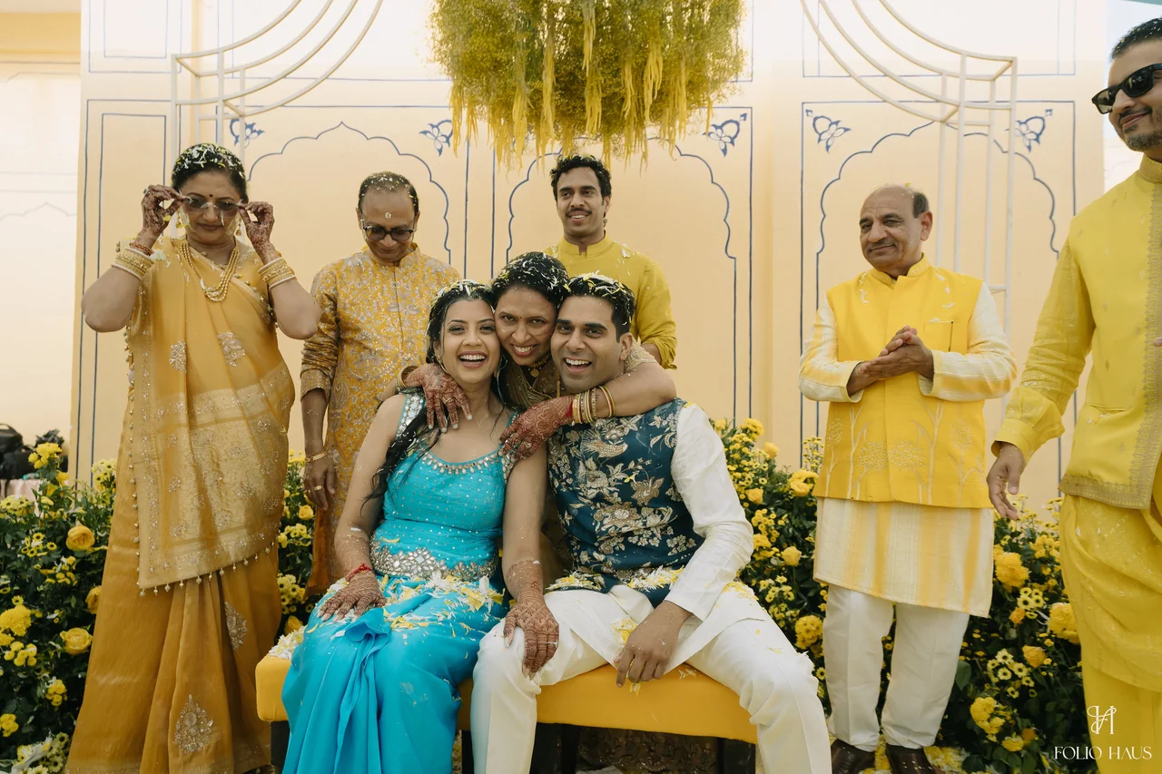 Jigna and Anurag smiling with guests at their Haldi celebration.