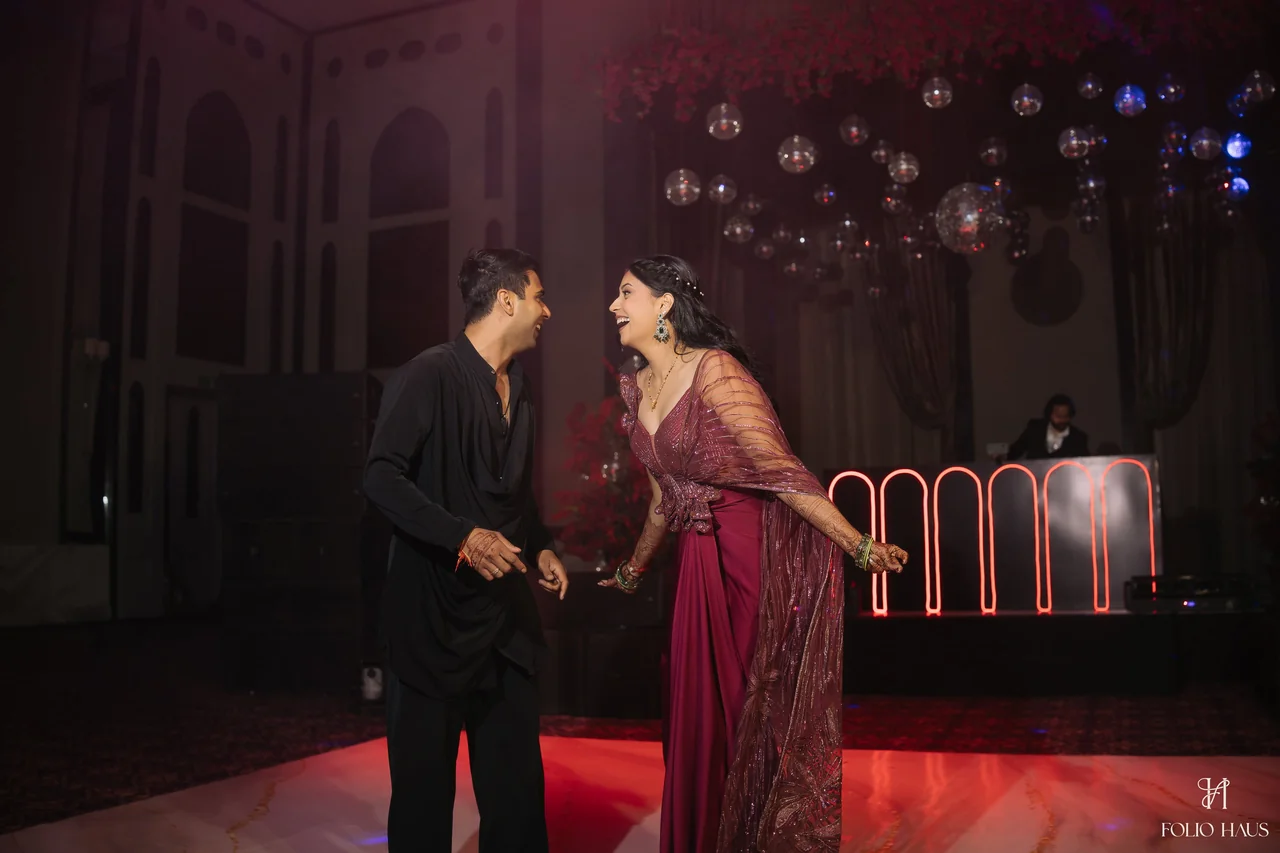 Jigna and Anurag together at their after-party under red lighting.