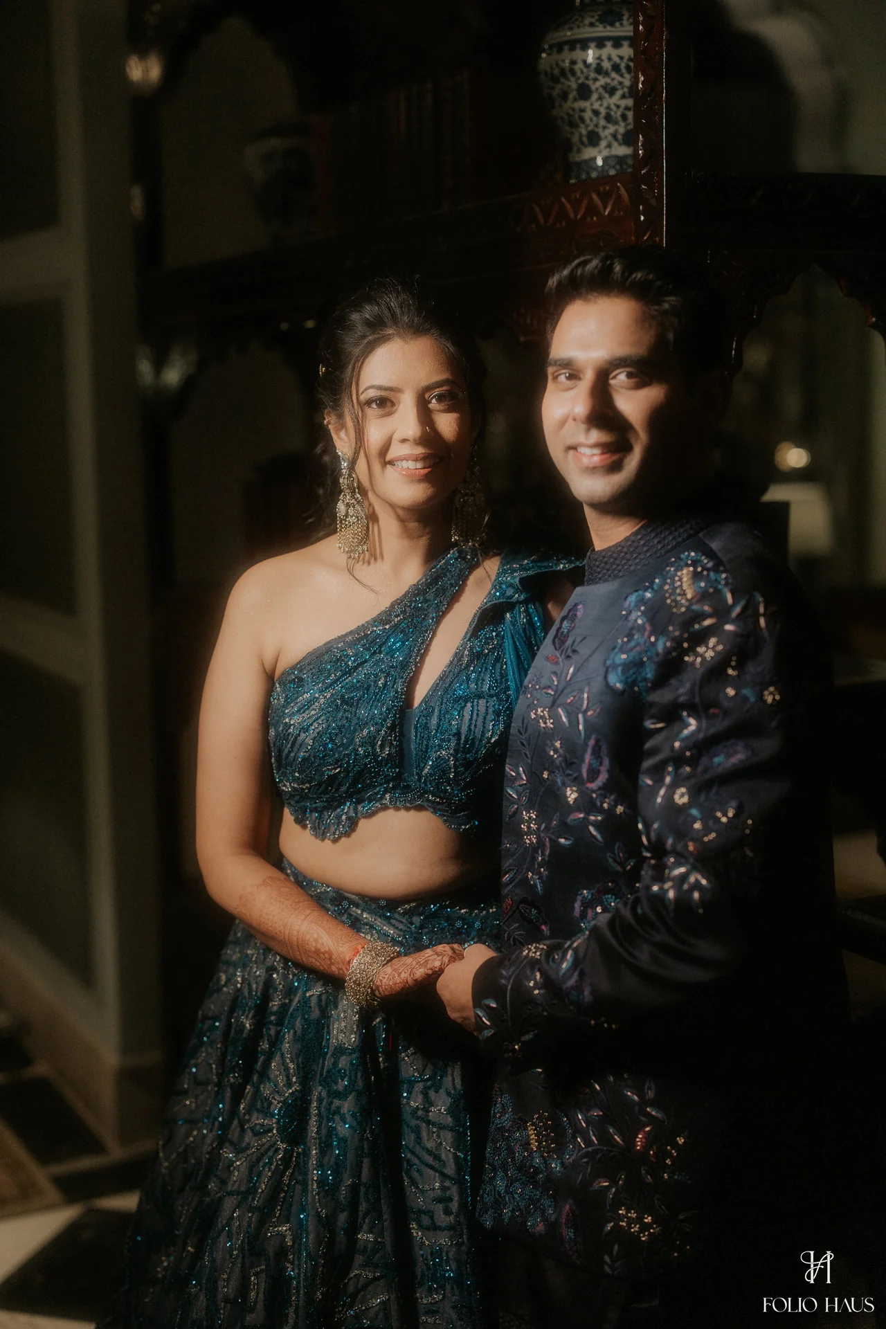 Jigna and Anurag standing together in their blue Sangeet outfits.