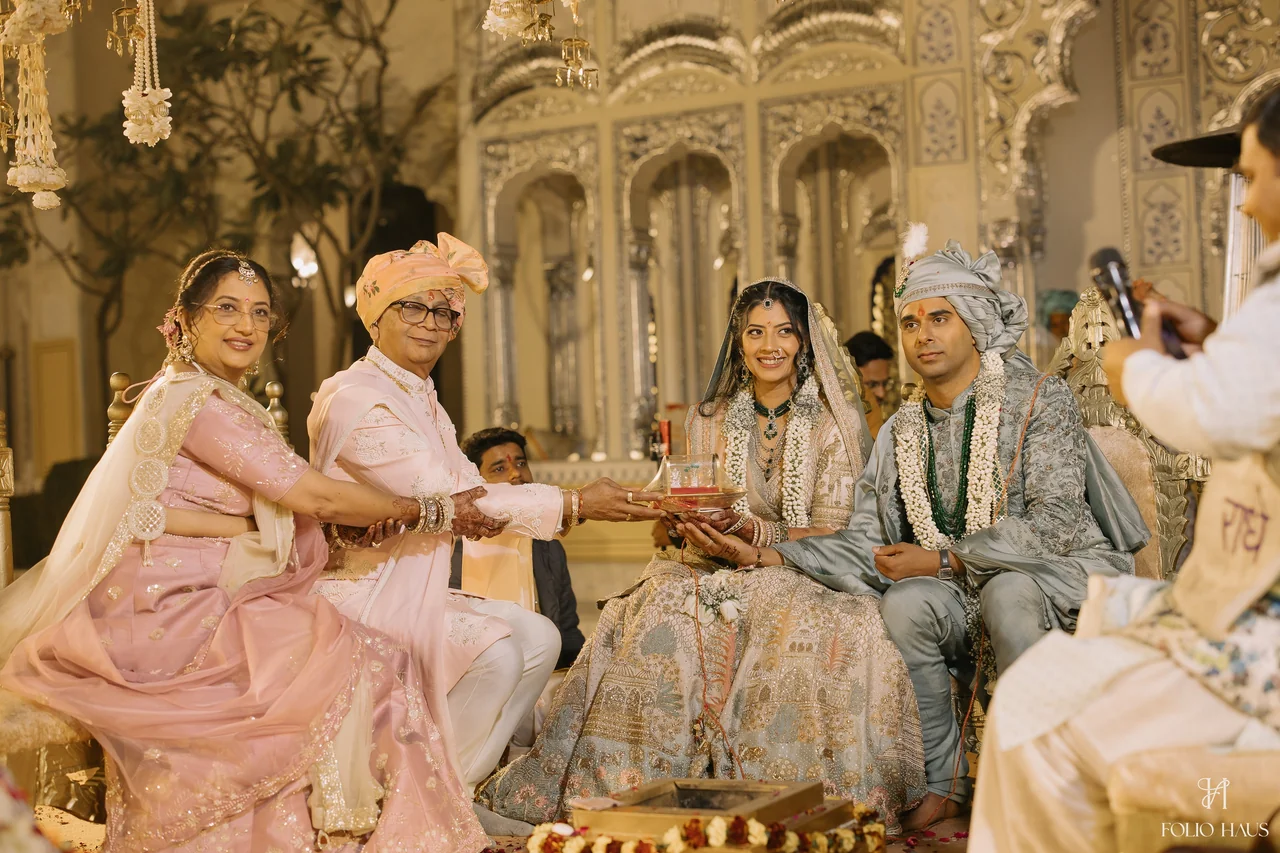 Jigna and Anurag sharing a ceremonial moment with seated guests.