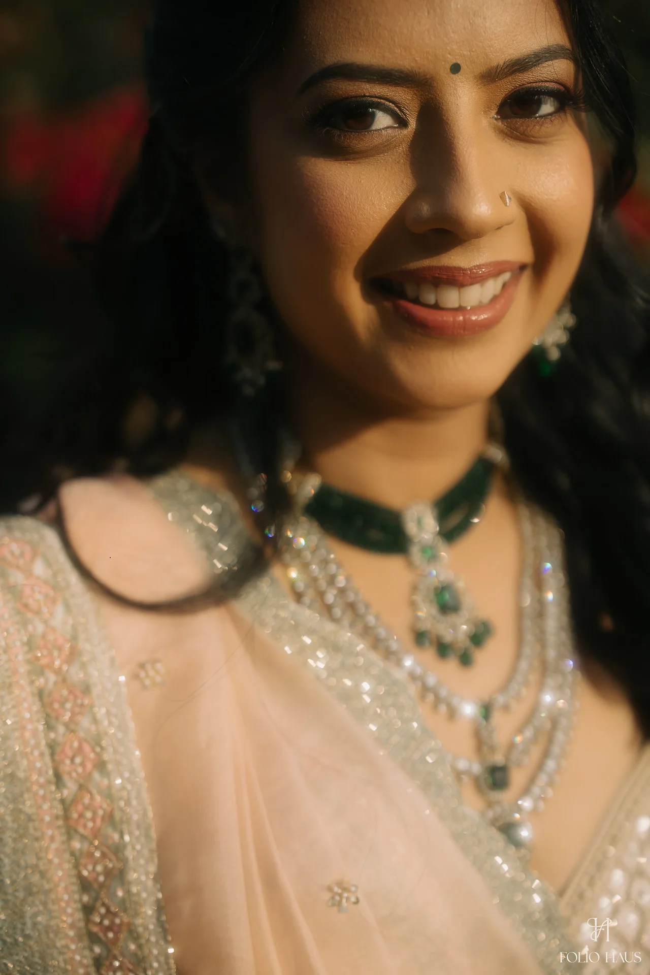 A close portrait of Jigna smiling in her wedding jewelry.